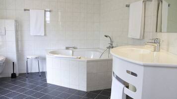 A modern bathroom with a bathtub, a sink, and a toilet.