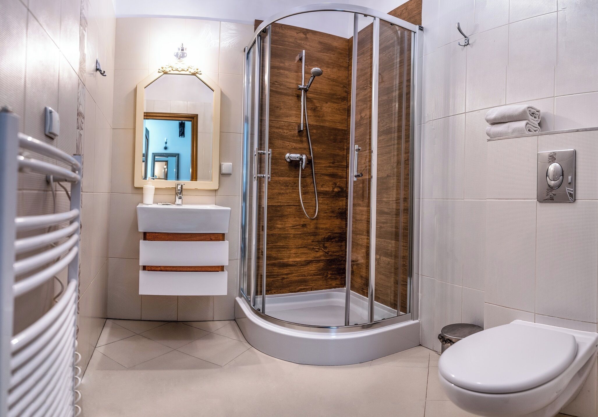 Een moderne badkamer met een douchecabine van glas, een witte wastafel met spiegel en een toilet.