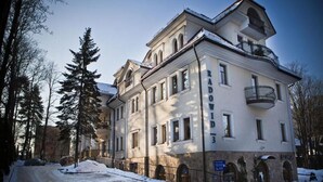 A multi-story building with a classic architectural style, featuring a balcony on the upper floor. - Tatrytop Apartamenty Radowid (Zakopane)
