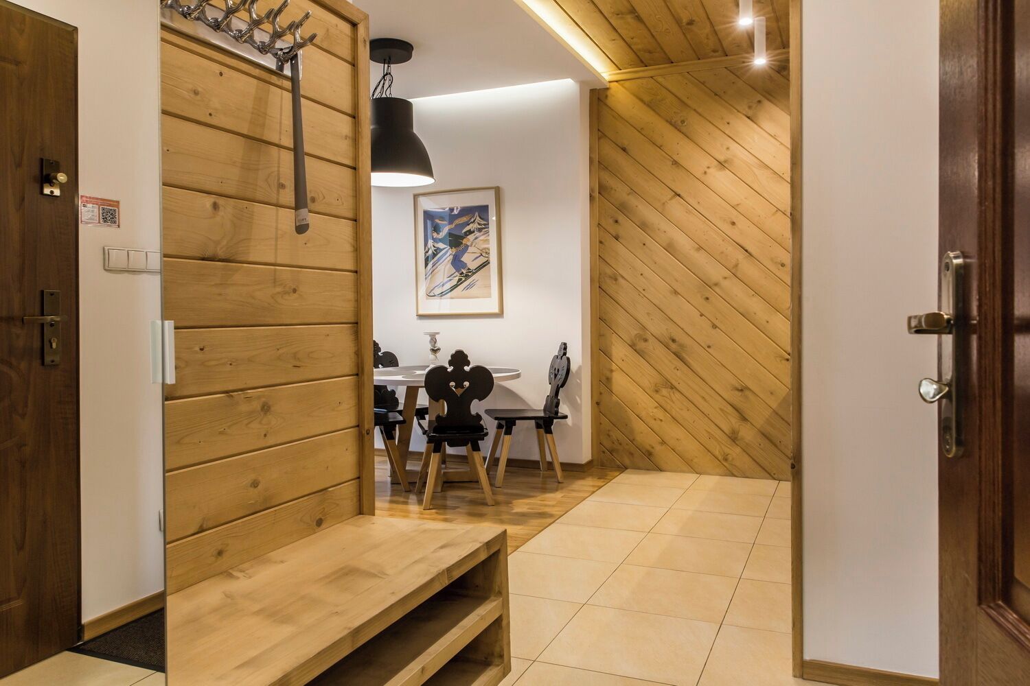 A wooden interior with a dining area, a bench, and a door.