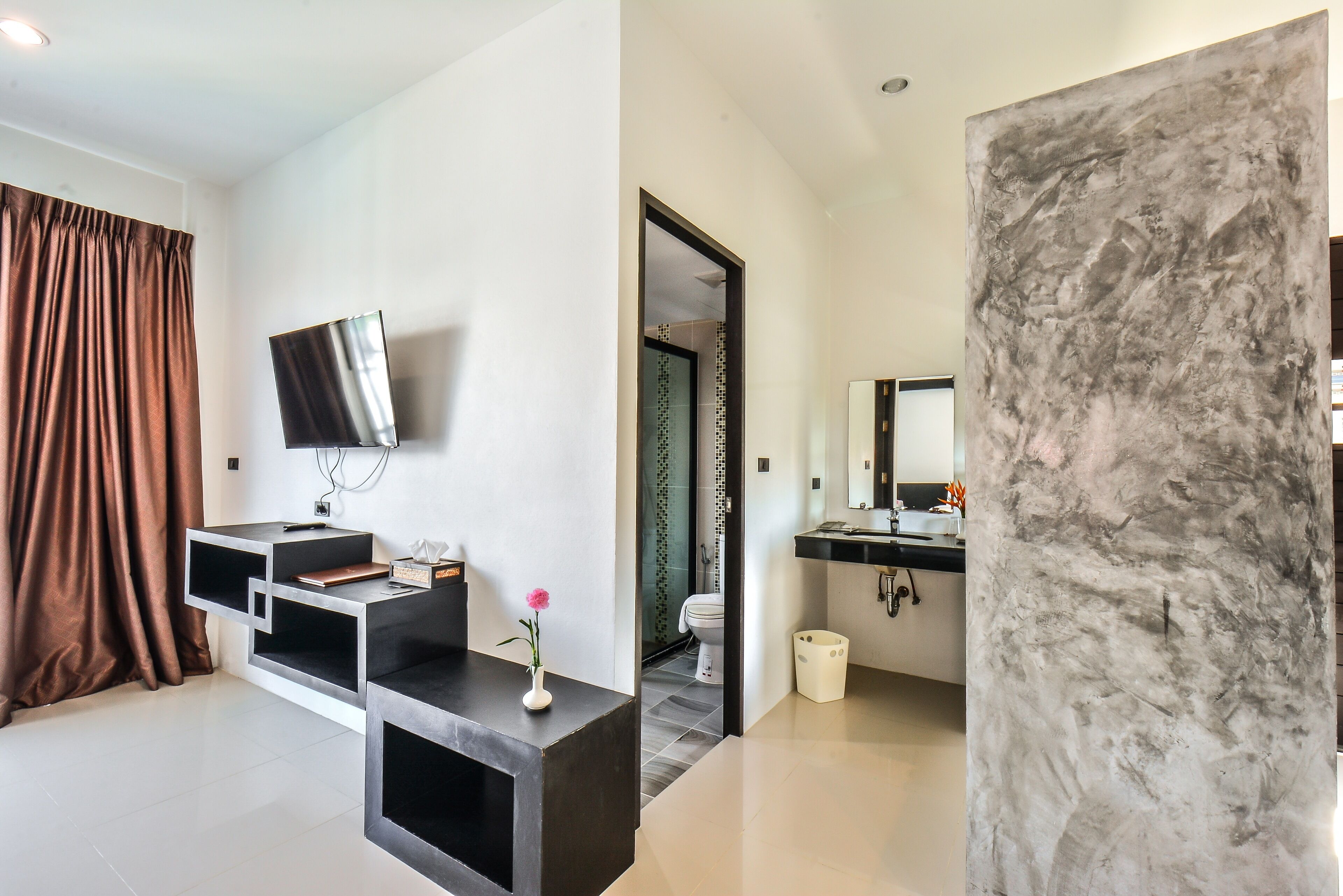 Ein modernes Badezimmer mit Marmorwand, Waschbecken und Spiegel.