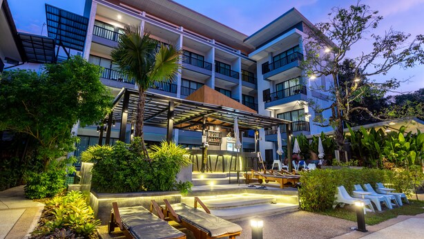 Un hotel con bar en la azotea, asientos al aire libre y exuberante jardinería.