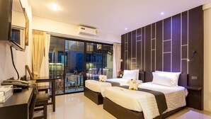 Habitación de hotel con cama, mesitas de noche, escritorio y vistas al exterior.