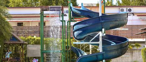 Parque acuático con múltiples toboganes y una piscina.