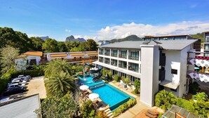 Un hotel con piscina, zona de juegos para niños y vistas a las montañas.