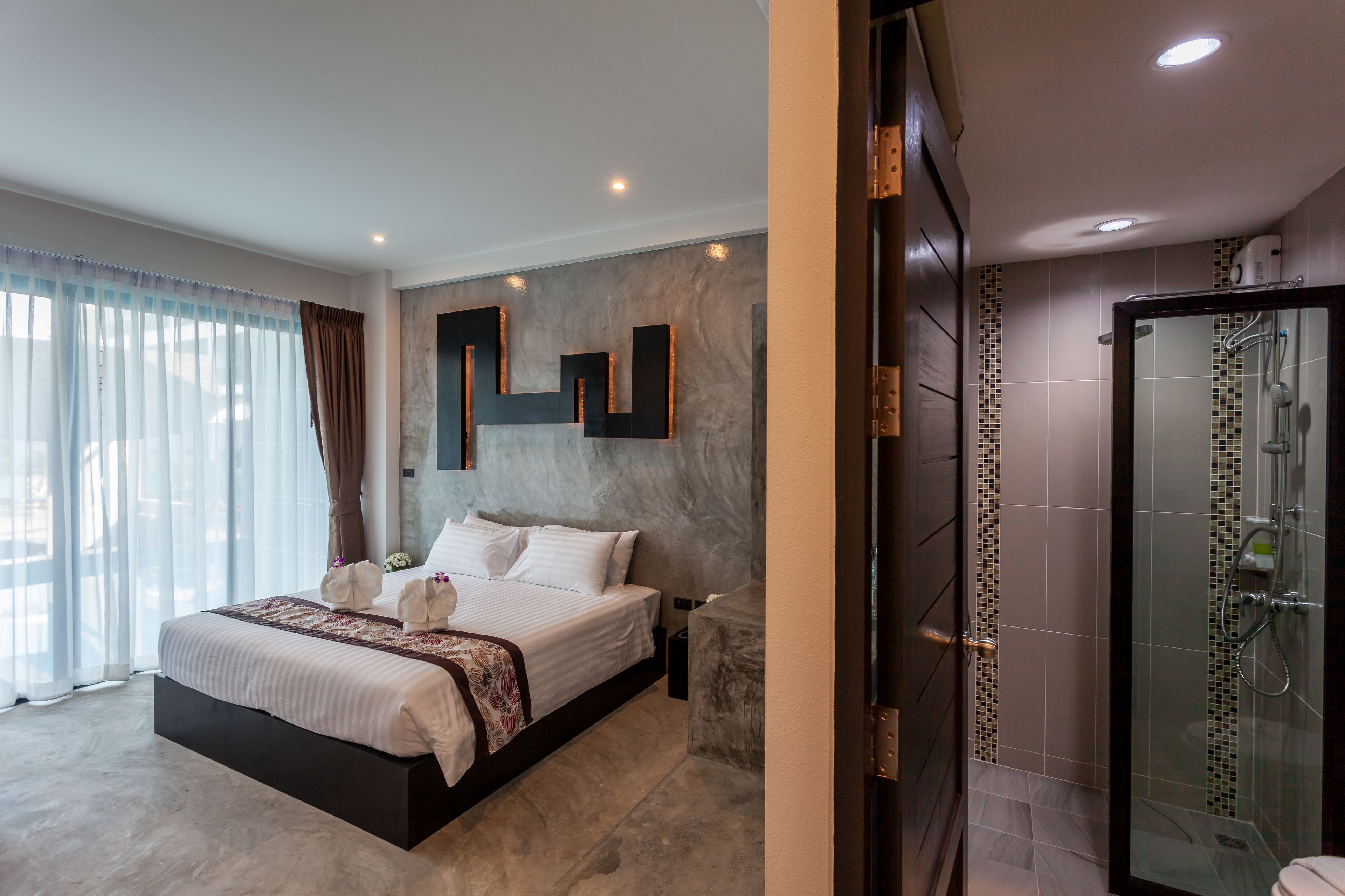 A modern bedroom with a large bed, a shower area, and a view of the outdoors.