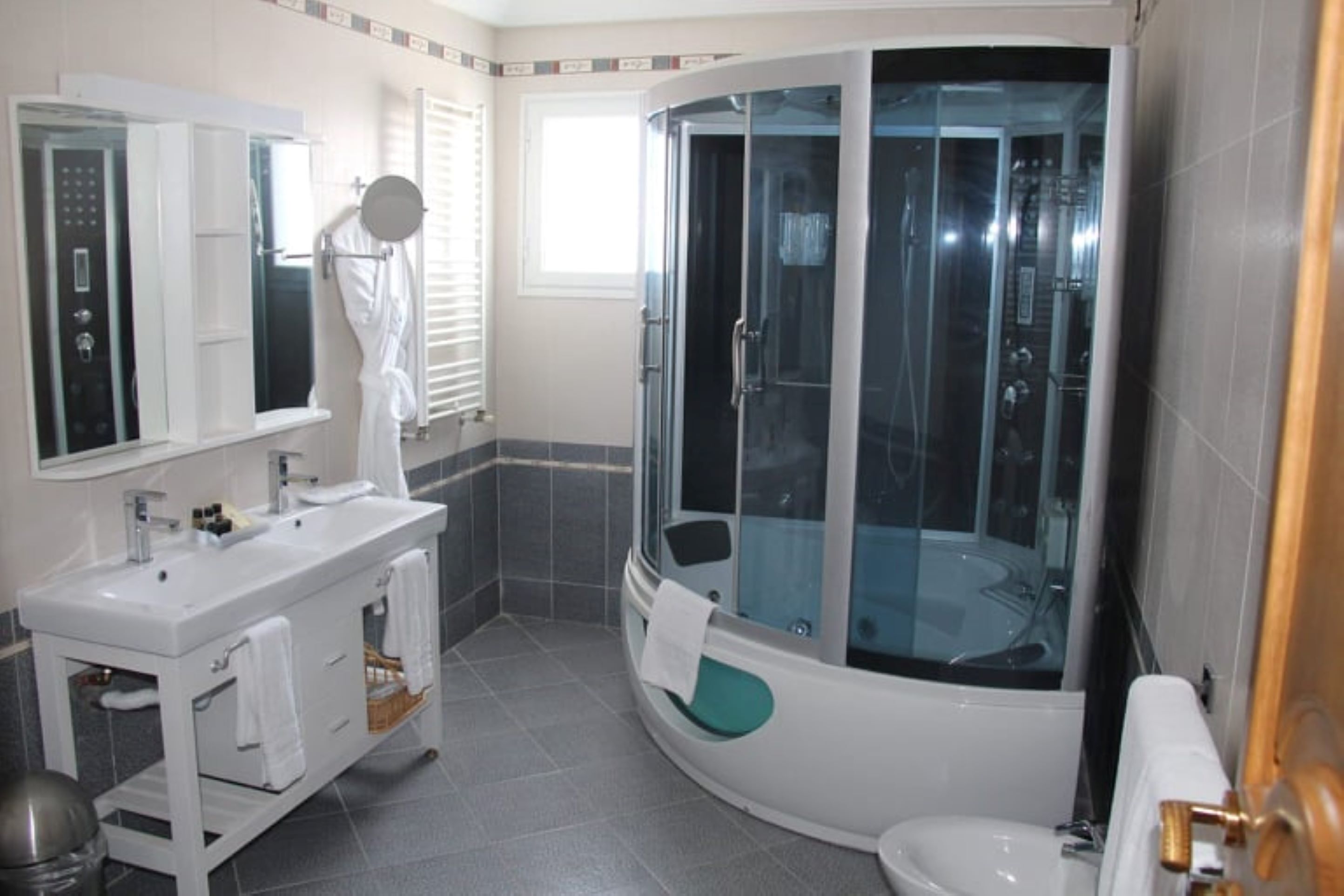 A modern bathroom with a glass-enclosed shower, a white vanity with a mirror, and a toilet.