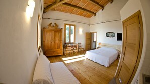 A bedroom with a wooden ceiling, a bed, a desk, and a wardrobe. - Agriturismo Campanacci (Faenza)