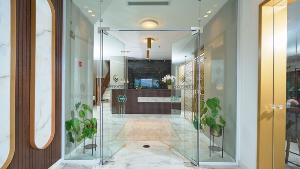 A hotel reception area with a marble floor, glass doors, and a reception desk. - Hotel Filippos (Chalkidona)