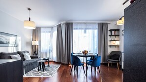 Una sala de estar moderna con sofá, mesa de comedor, sillas y estantería.