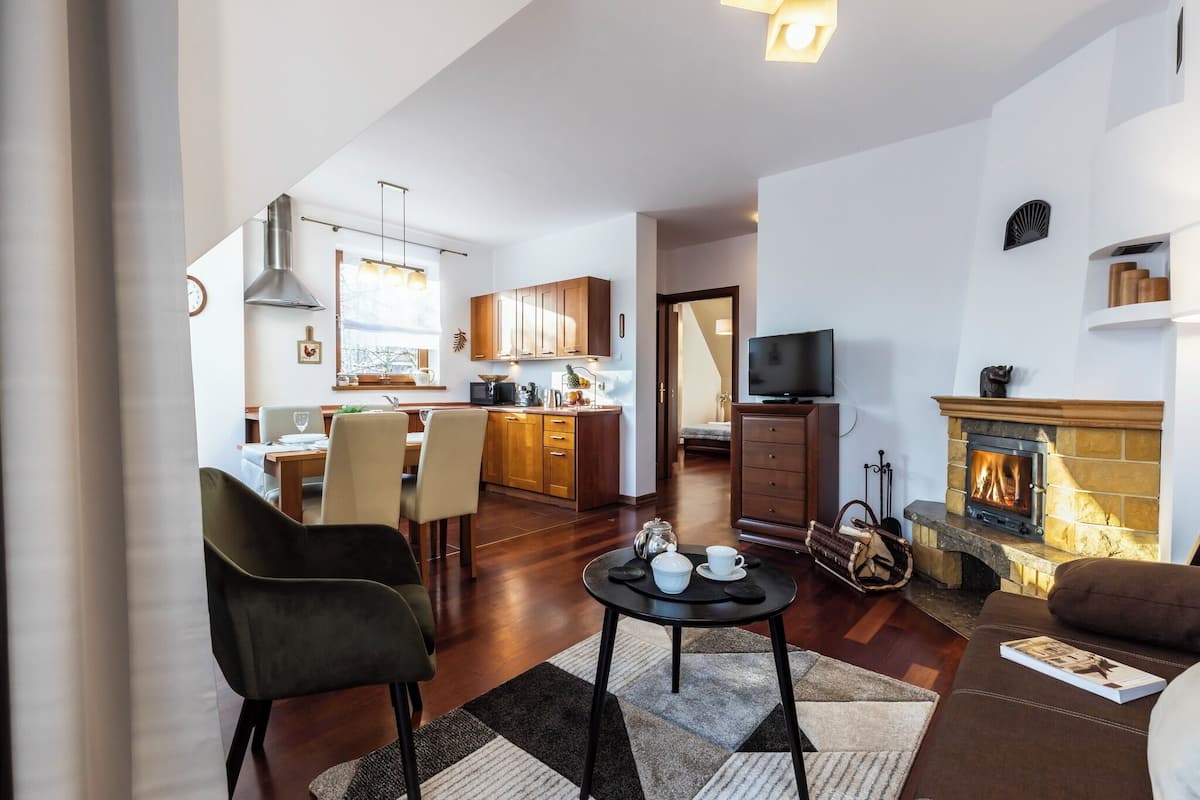 Una sala de estar moderna con chimenea, un comedor y una cocina.