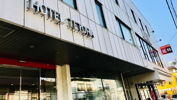 Un bâtiment d’hôtel moderne, sur lequel on peut lire l’inscription  « HÔTEL TEFORA ».