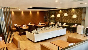 Un restaurant moderne doté d’un plancher en bois, de banquettes et d’un buffet.