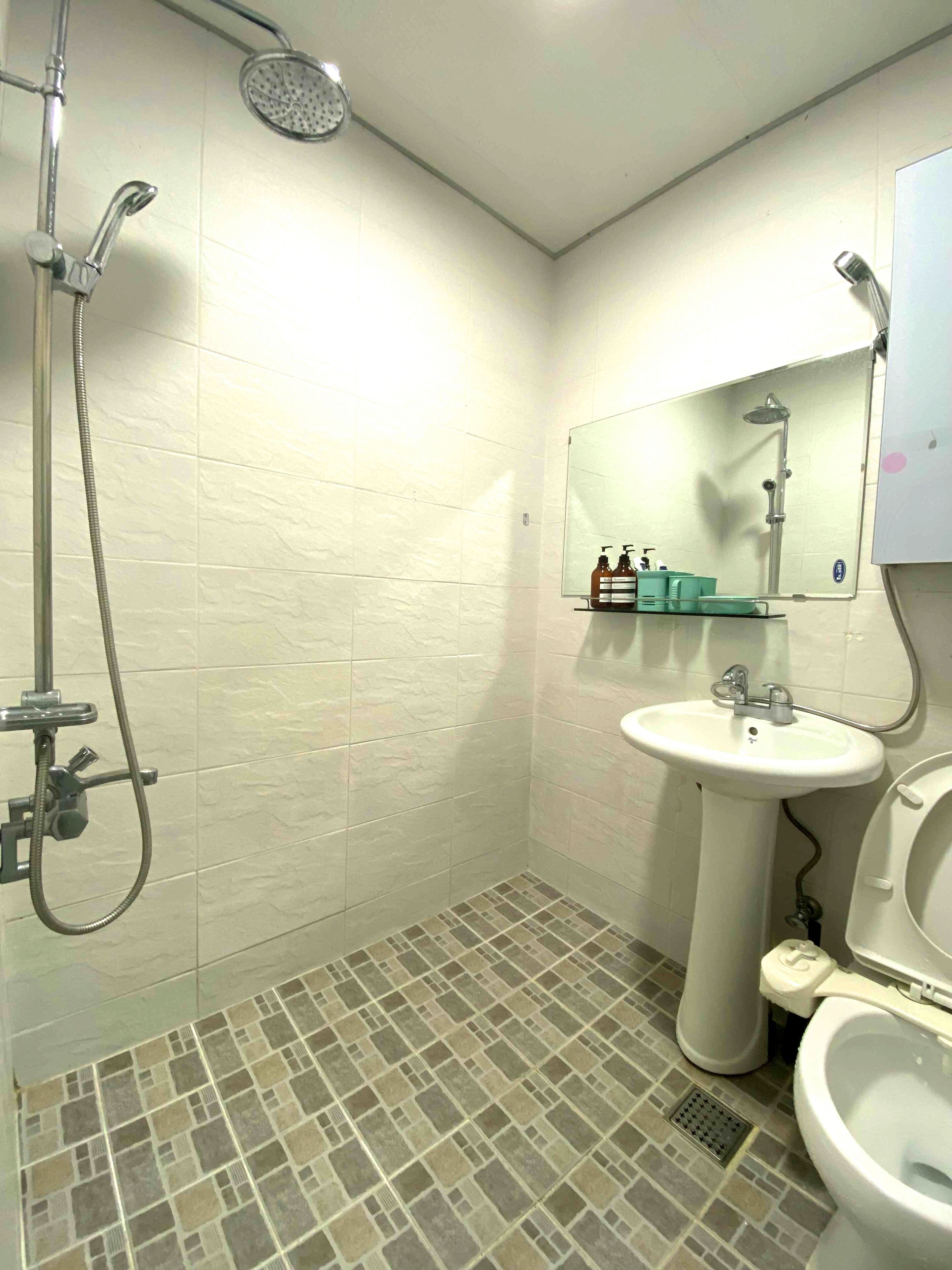 A bathroom with a shower, sink, and toilet.
