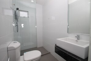 A modern bathroom with a glass-enclosed shower, a white toilet, and a sink with a mirror above it. - Ipoh Boutique Hotel (Ipoh)