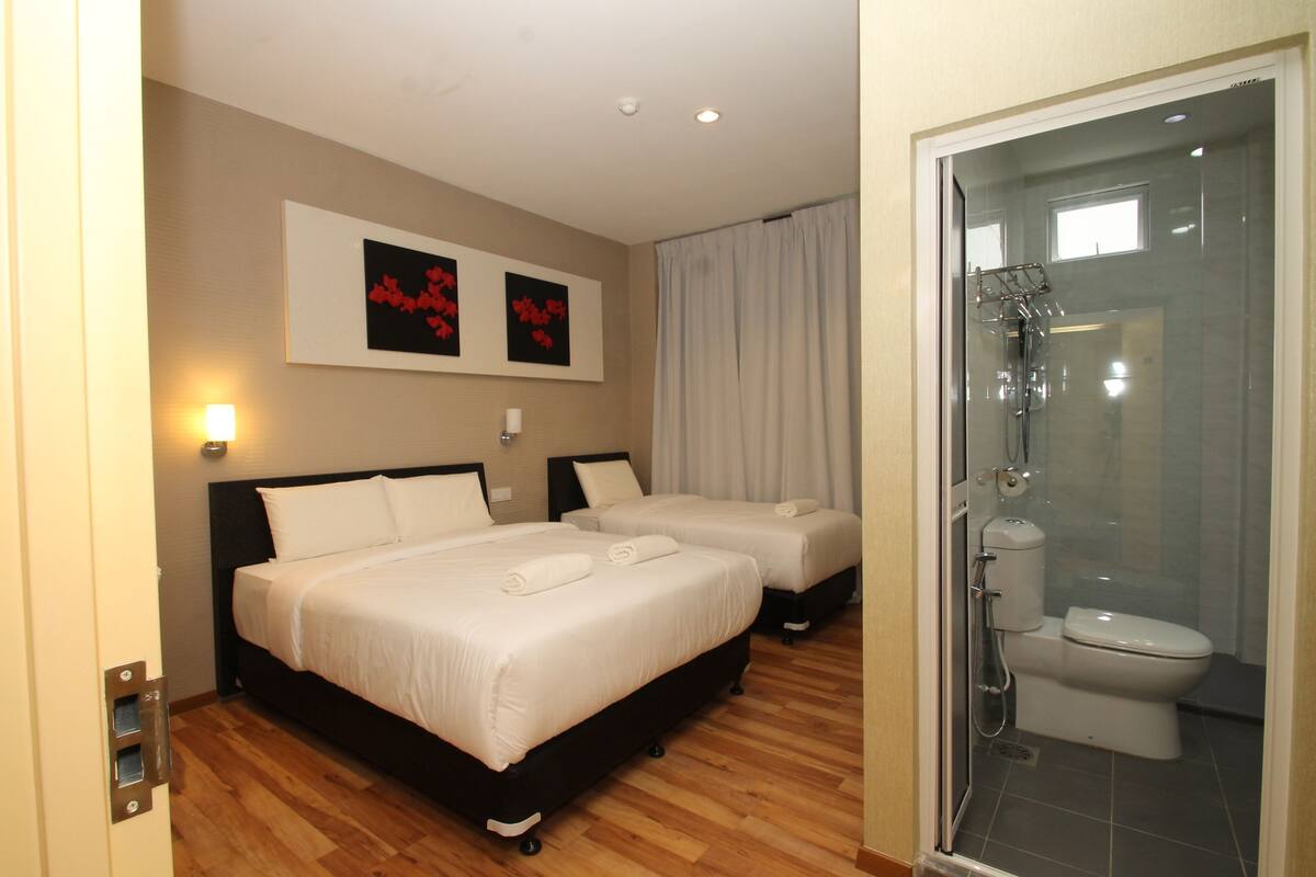 Une chambre d’hôtel avec deux lits, une douche et des toilettes.