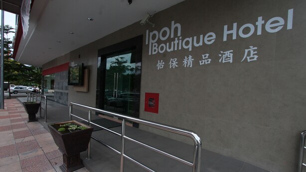 L’extérieur de l’hôtel boutique Ipoh se caractérise par une façade moderne, une rambarde en métal et des plantes en pot.