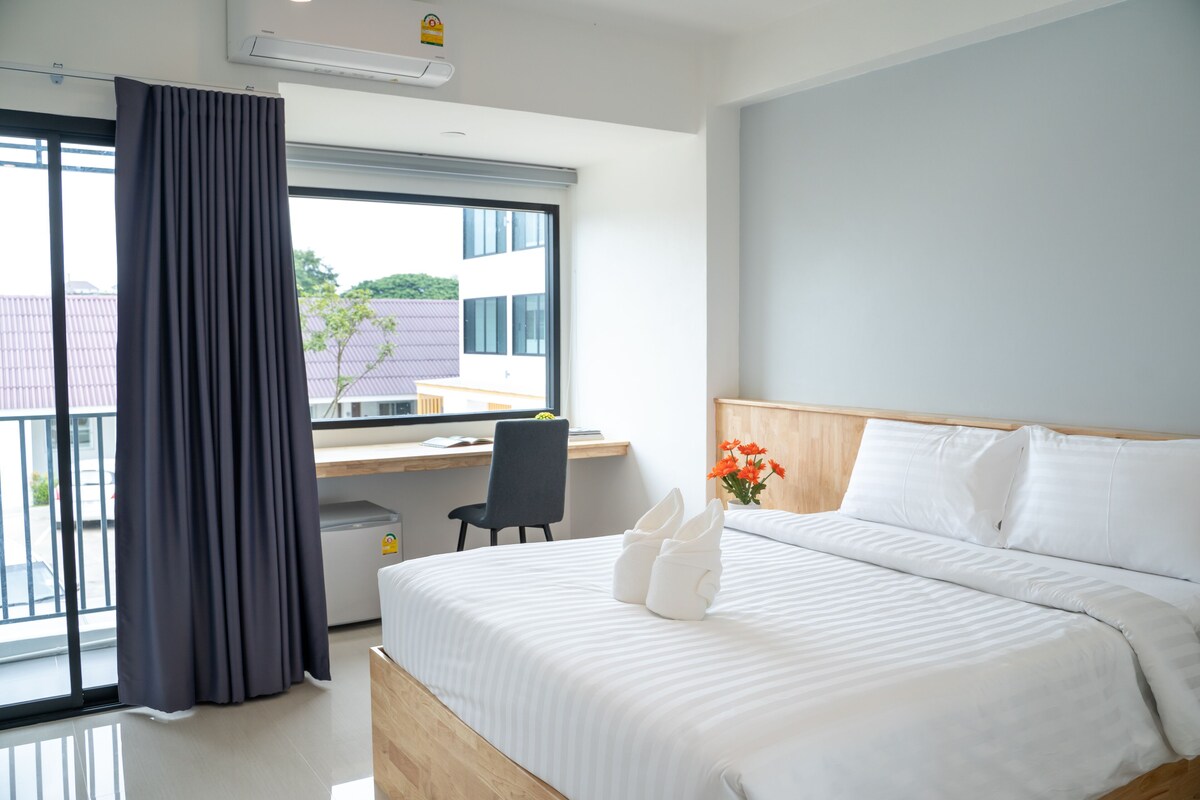 Una habitación de hotel con una cama, un escritorio y una silla.