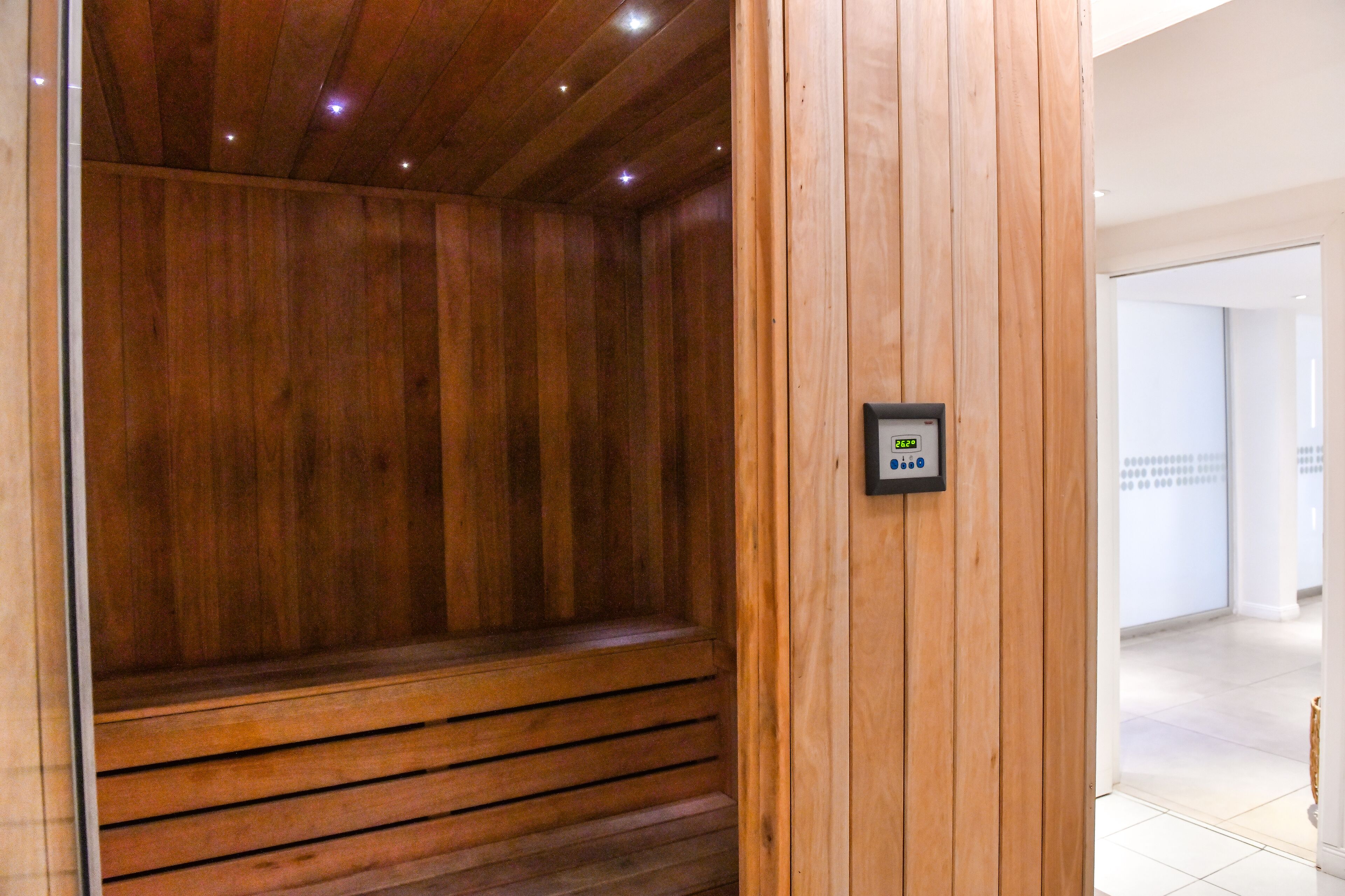 Un sauna en bois avec un panneau de commande fixé au mur.