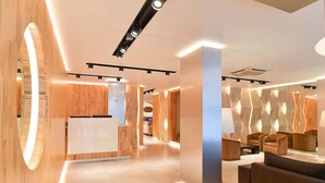 A modern lobby with wooden paneling, a reception desk, and seating areas. - Hotel Denver (Mar del Plata)