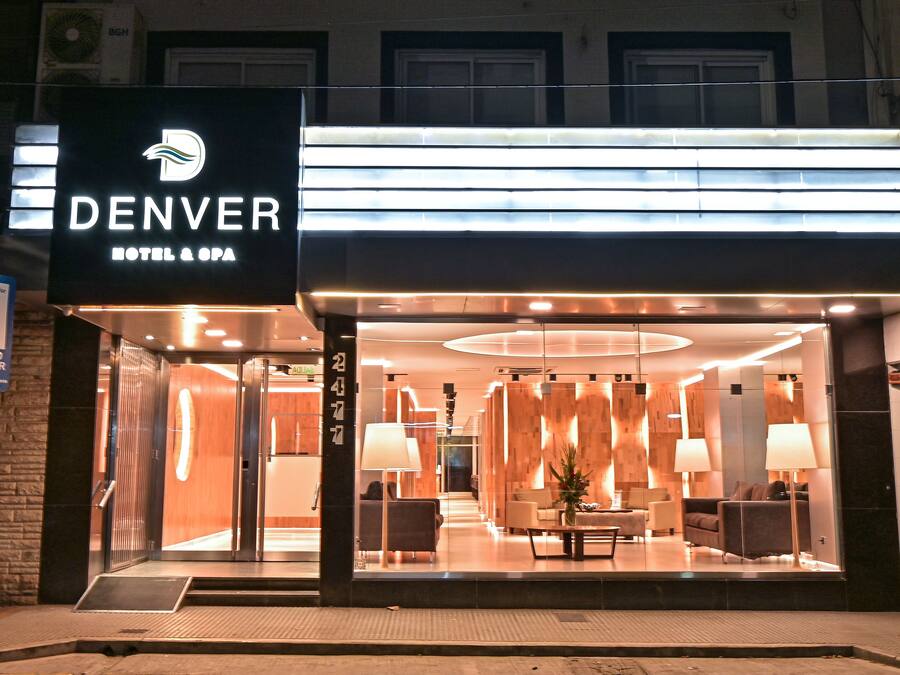 Entrada d'hotel amb un disseny modern, que inclou una zona de recepció amb seients i un taulell d'informació.