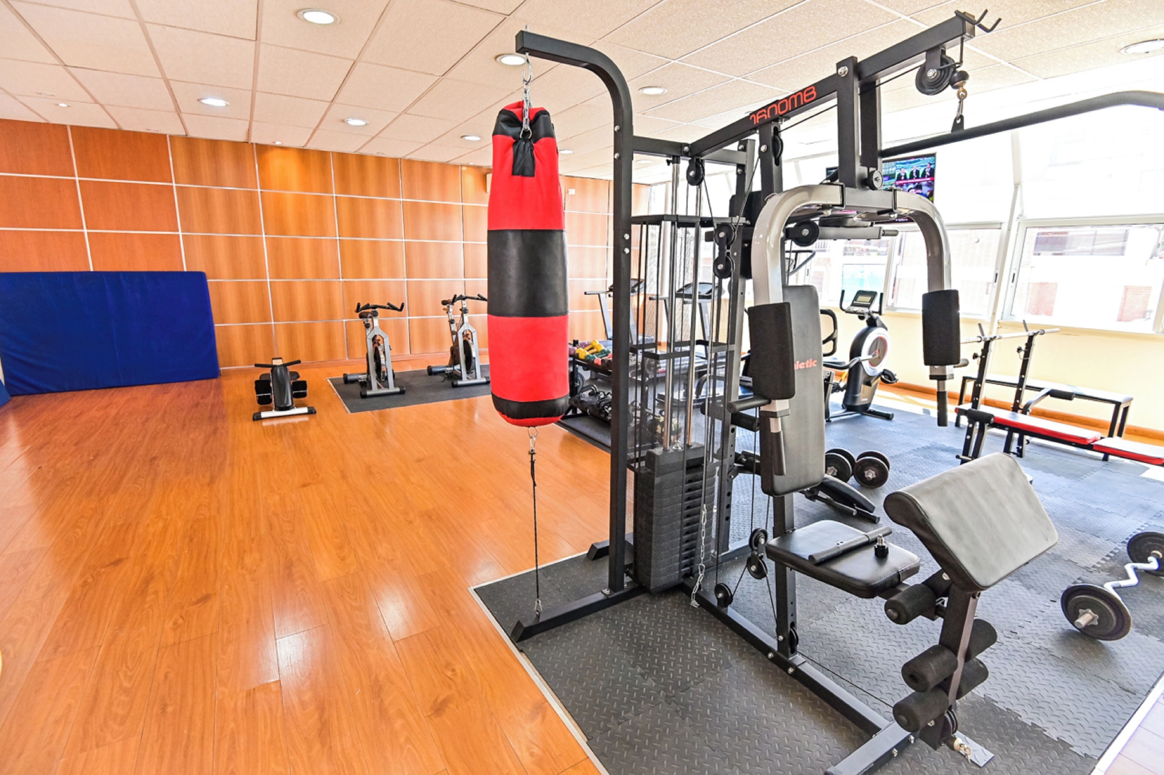 A gym with a punching bag, weight machines, and cardio equipment.