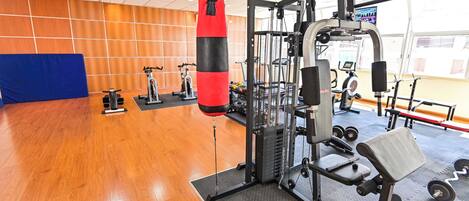 A gym with a punching bag, weight machines, and cardio equipment.
