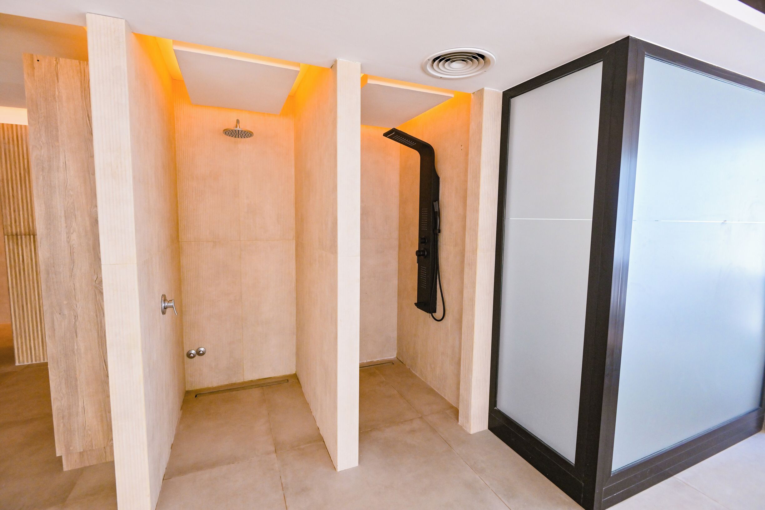 Un baño moderno con ducha, mampara de vidrio y puerta de madera.
