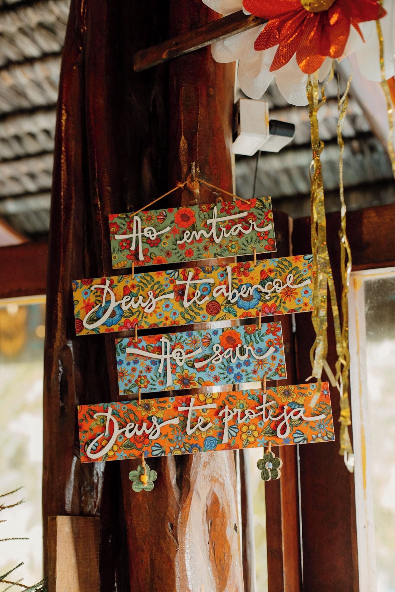A wooden structure with colorful, floral-patterned signs hanging from it.