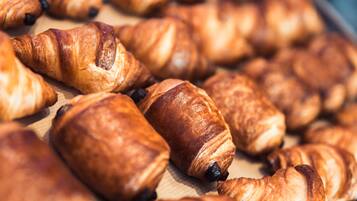 Een schaal met verschillende gebakjes, waaronder croissants en chocoladegebak.