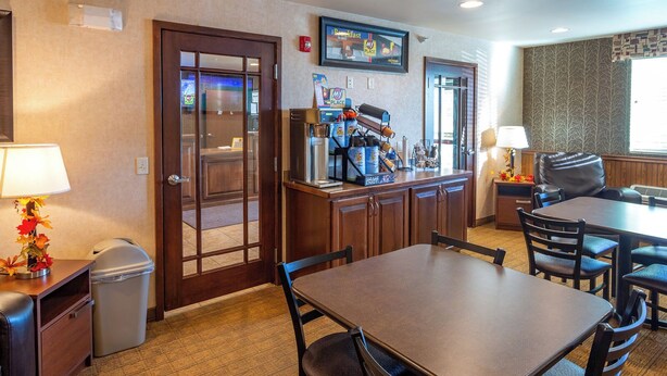 Habitación de hotel con comedor, cafetera y basurero.