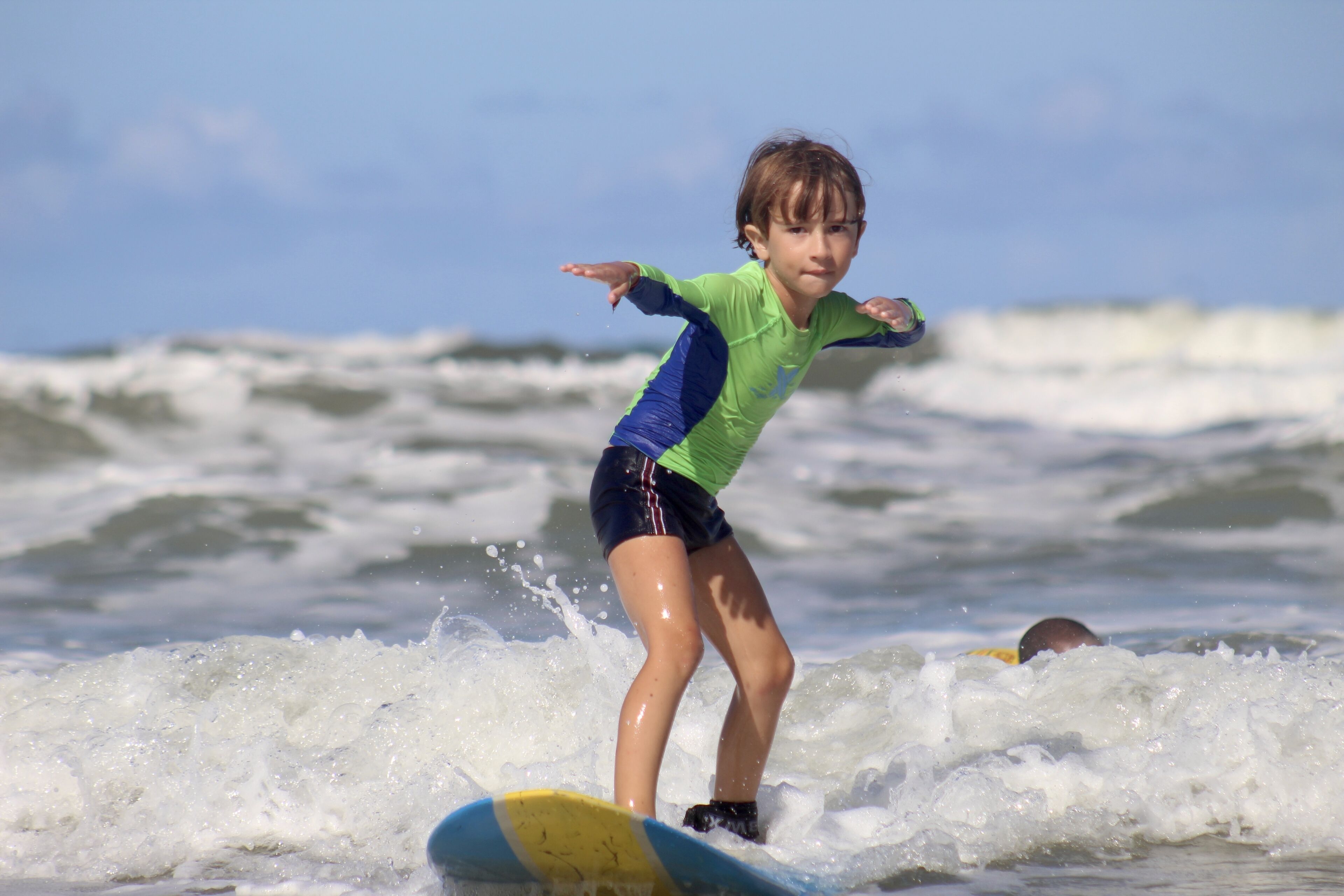 Uma criança surfando em uma onda.