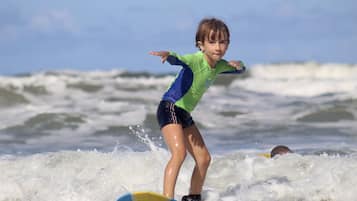 Uma criança surfando em uma onda.