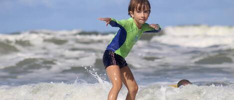 A child surfing on a wave.