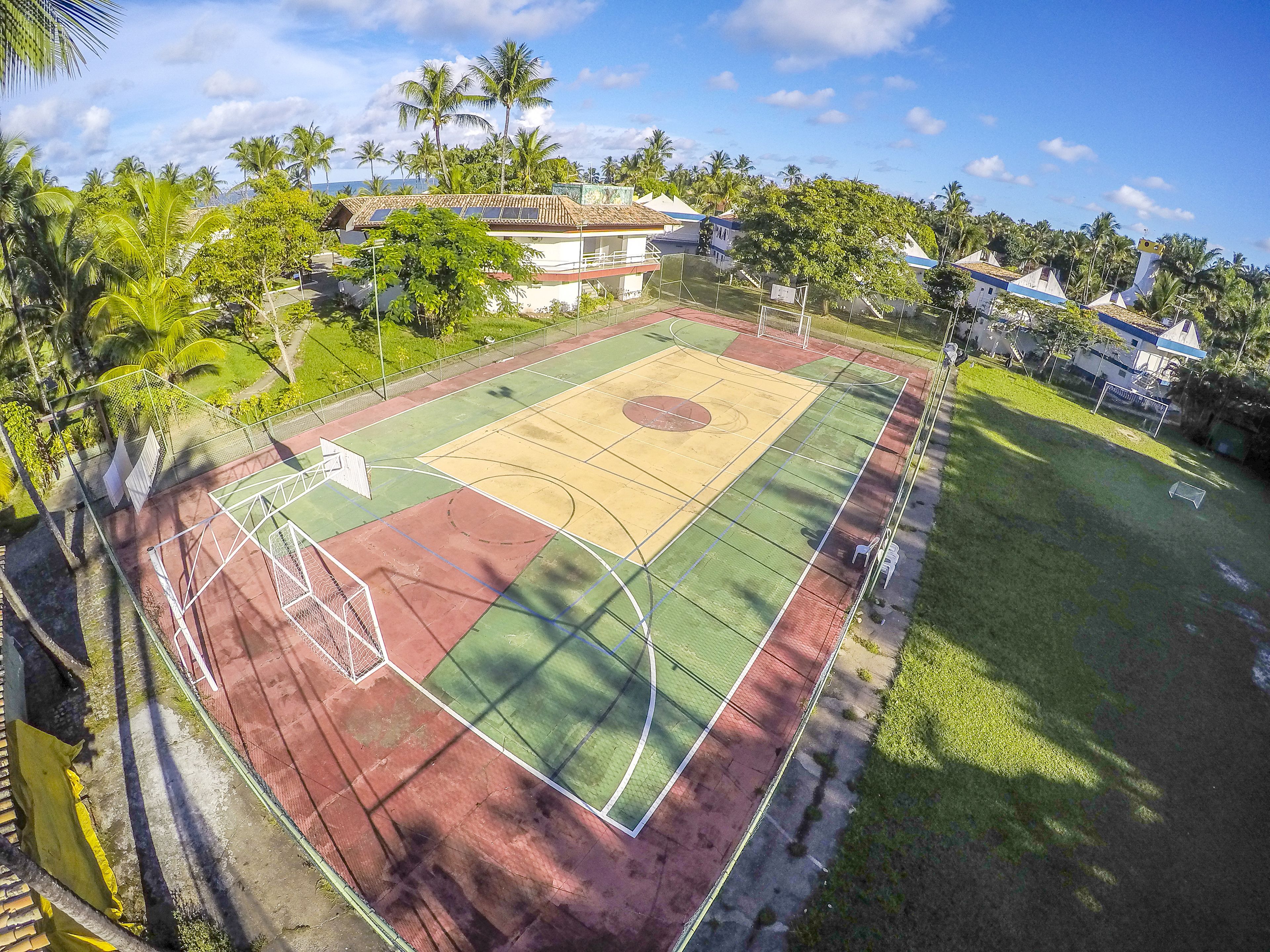 Ein Basketballplatz im Freien, umgeben von Grünflächen und Wohngebäuden.