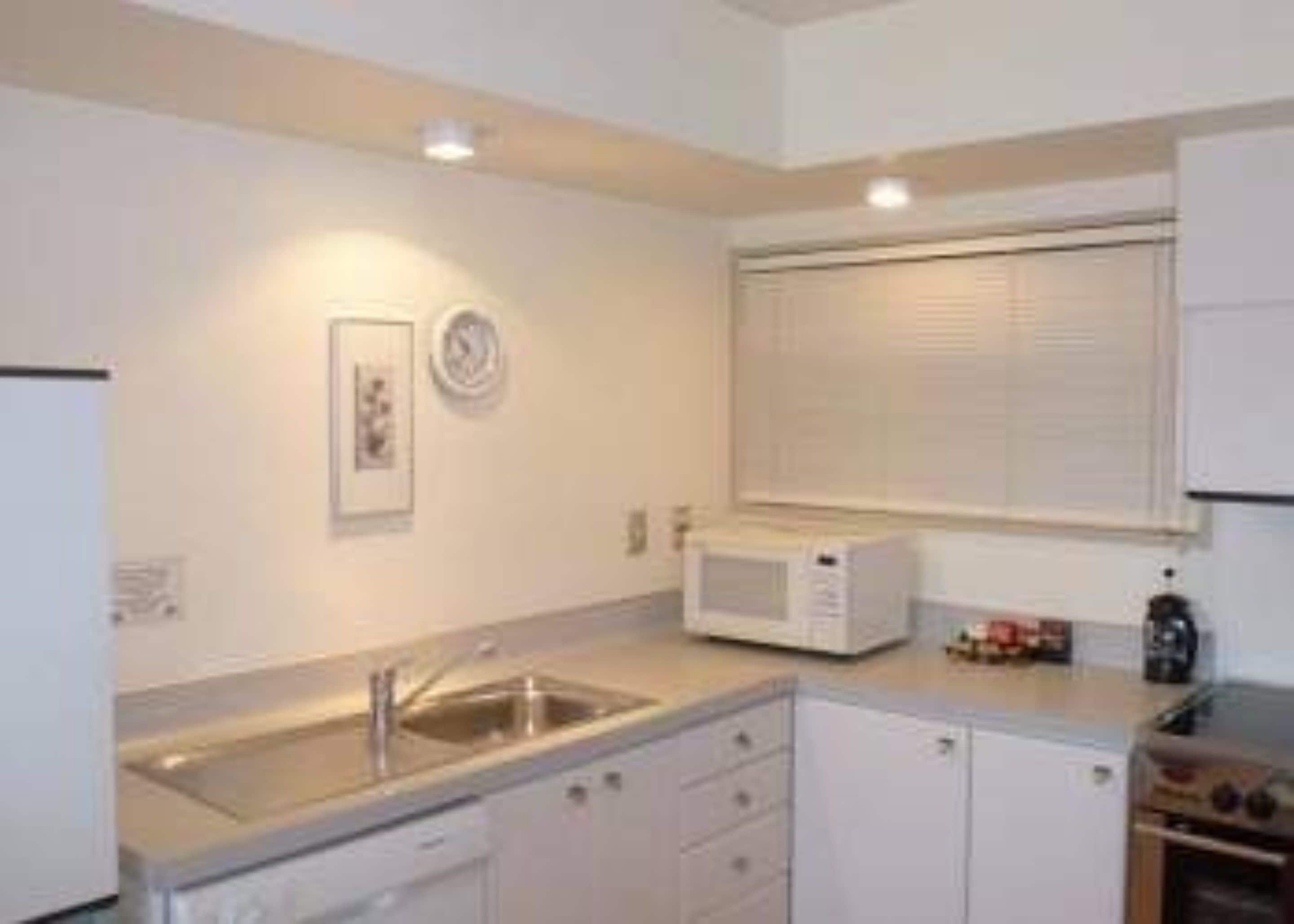 A compact kitchen with a sink, microwave, and oven.