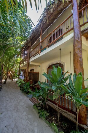 A two-story building with a wooden balcony and a thatched roof. - Playa Canek Hotel Boutique Spa (Mexico)