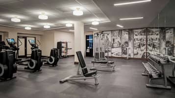 A gym with exercise equipment, including treadmills, weight machines, and dumbbells.