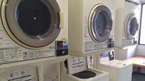 A row of stacked front-loading washing machines in a commercial setting. - Sunwell Kotohira (Kotohira)