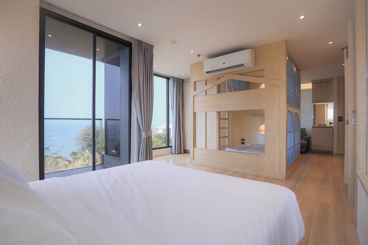 Un dormitorio con una cama grande, una litera y vistas al mar.