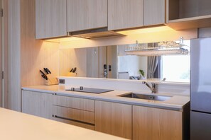 Une cuisine moderne avec des meubles en bois, un évier en acier inoxydable et un four encastré.