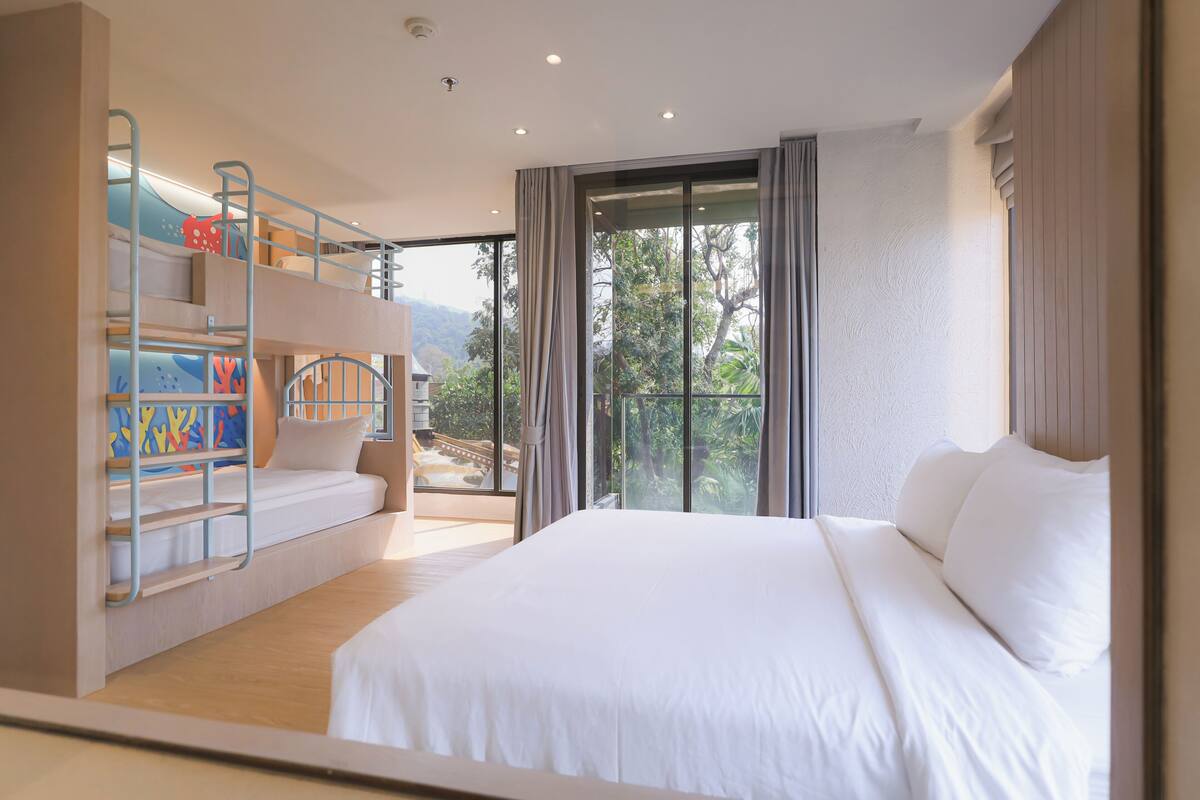Un dormitorio con una cama litera, una cama grande y vistas por una puerta corrediza.