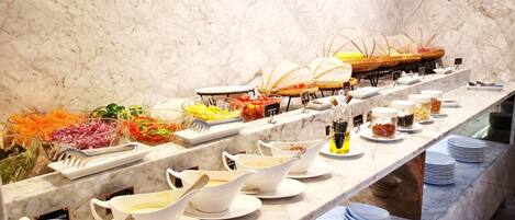 A buffet with various food items and serving utensils.