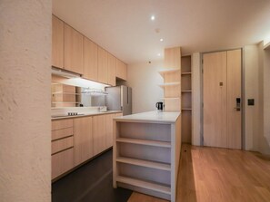 Une cuisine moderne avec des meubles en bois, un plan de travail blanc et des étagères intégrées.
