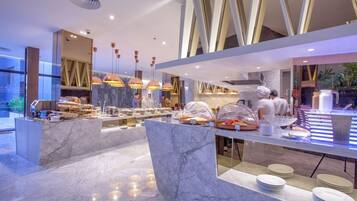 A modern buffet setup with marble countertops and overhead lighting.