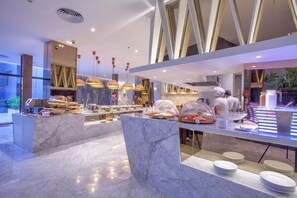 Un buffet moderne avec des plans de travail en marbre et un éclairage suspendu.