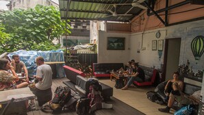 A communal outdoor area with seating and tables, surrounded by greenery. - Step Inn Guest House (Kuala Lumpur)