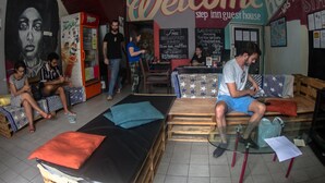 A guesthouse interior with a mural, a Twister vending machine, a welcome sign, and a bed with a pillow. - Step Inn Guest House (Kuala Lumpur)
