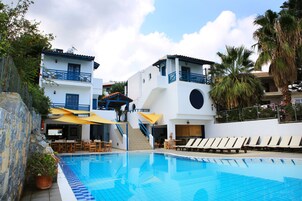 Zona de piscina con sillas de descanso y una escalera que lleva a pisos superiores.