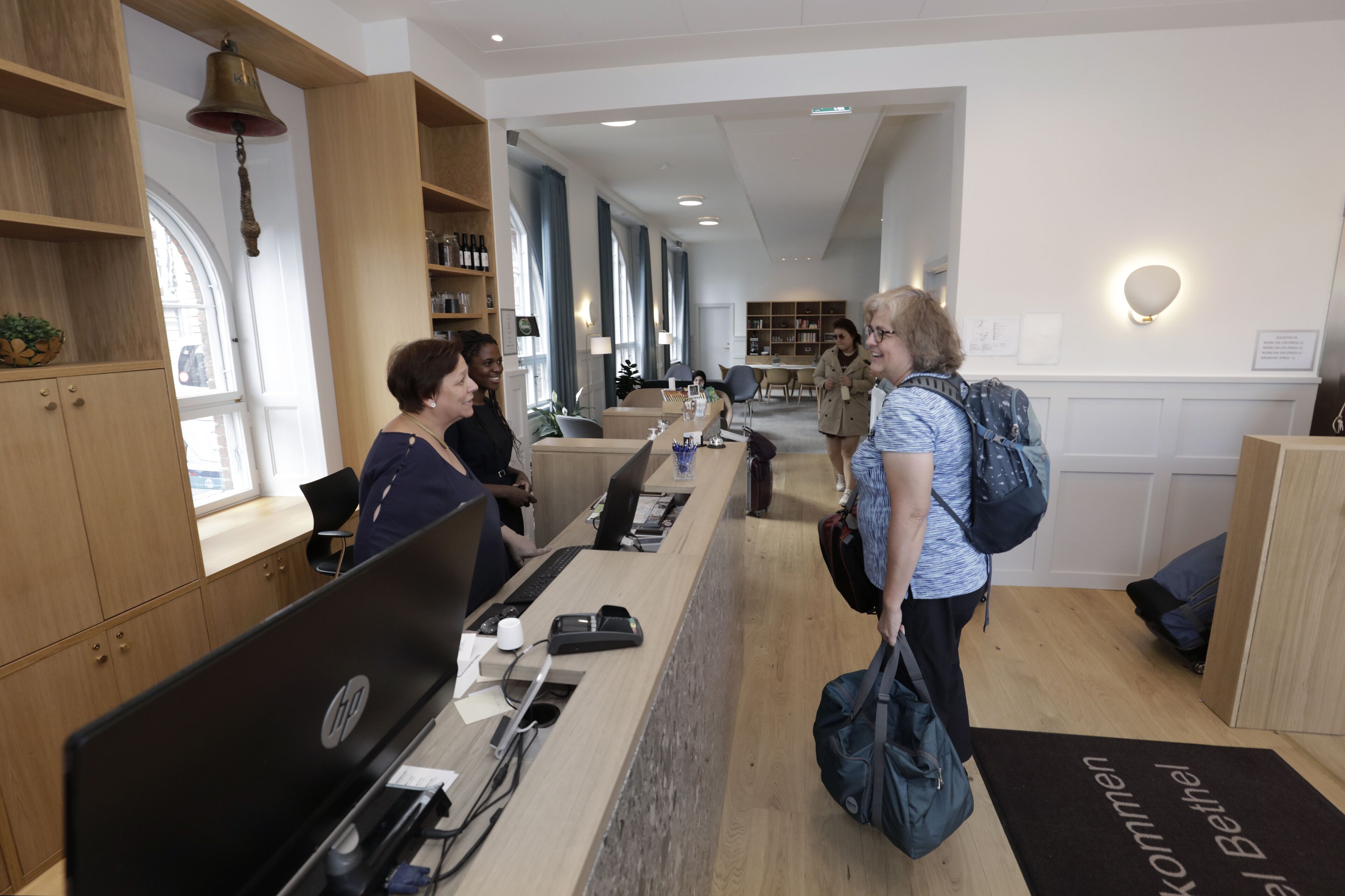 A reception area with a wooden desk, computers, and a welcome mat.